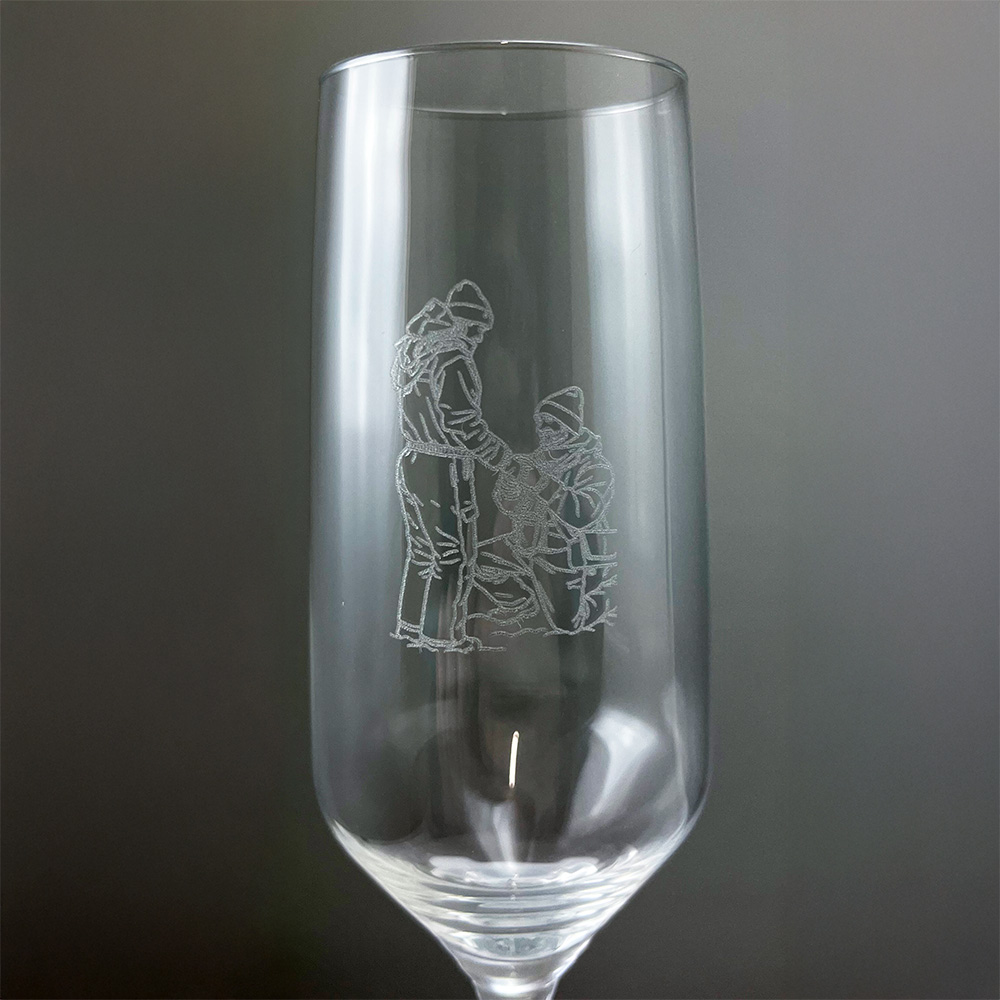 Graviertes Sektglas mit Liniengravur in Großaufnahme, personalisiertes Glas für Hochzeit oder Jubiläum